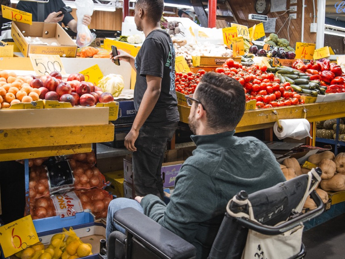 A support worker helping a participant with shopping at the central market