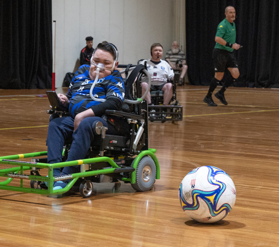 Powerchair football players competing for the ball